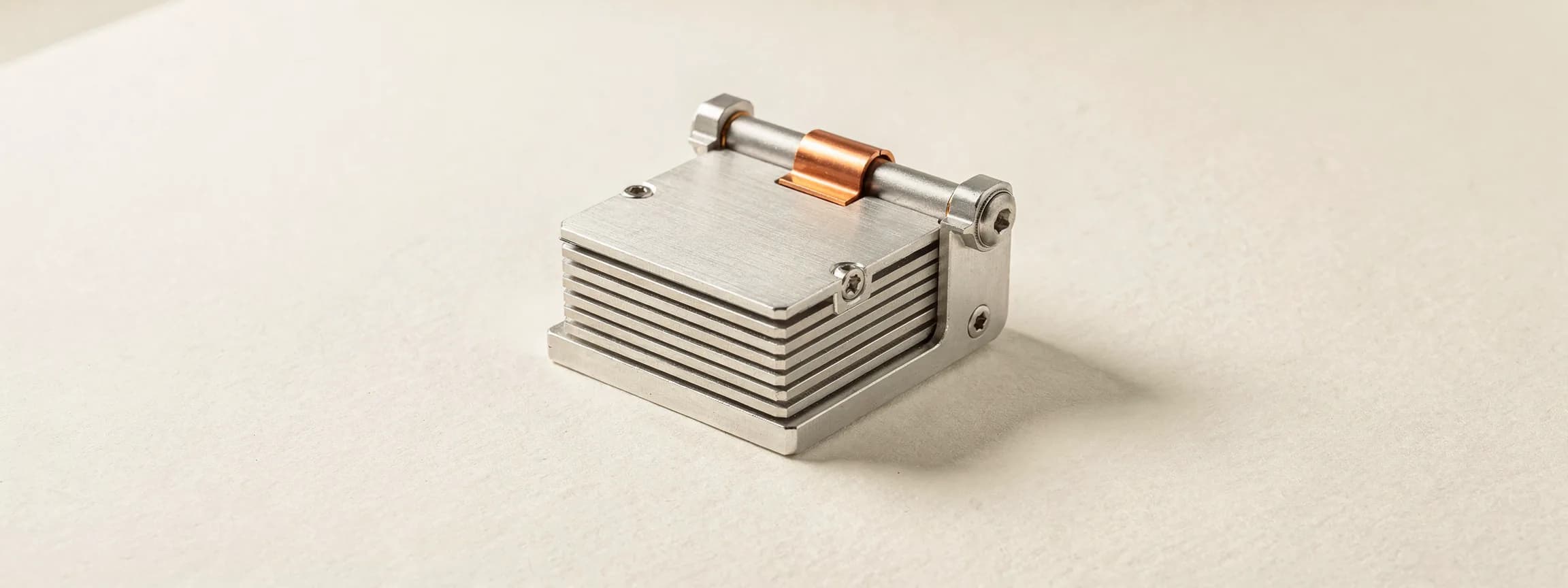 A machined aluminium flip calendar on a copper hinge, on paper.