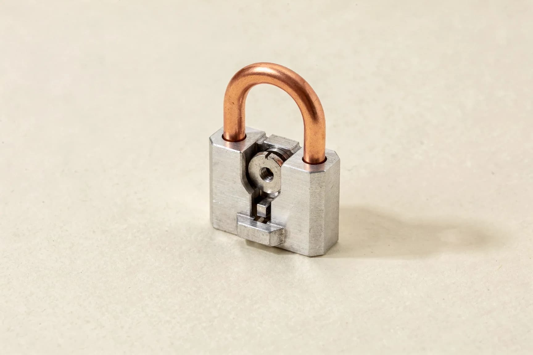 A small aluminium padlock with a copper shackle.