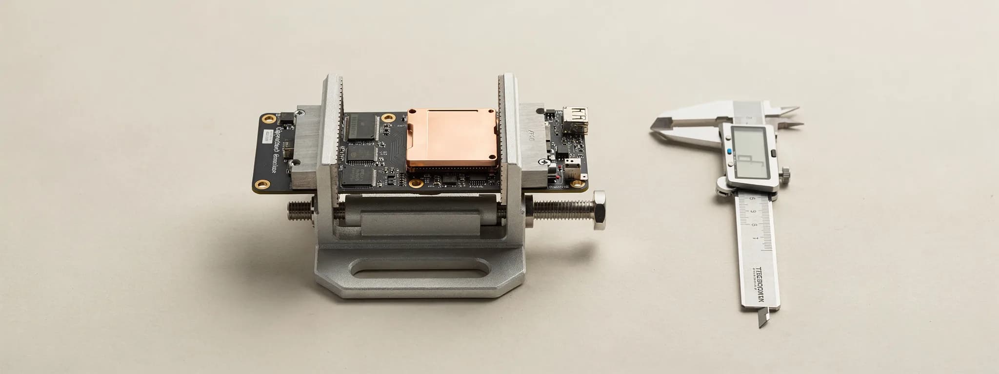 The bench: a vice holding a compute board with its copper plate, a calliper beside it.