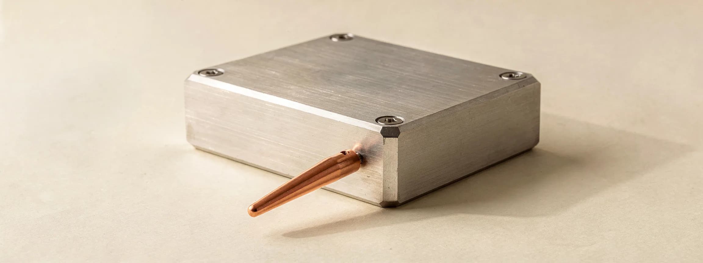 A brushed steel test bench with one copper probe clipped on, on paper.